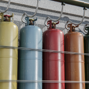 Profissional conferindo cilindros de gases medicinais identificados em ambiente hospitalar